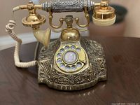 Front view of ornate Electra rotary telephone, dial visible
