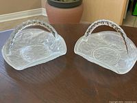Two frosted glass trinket baskets with floral pattern and handles