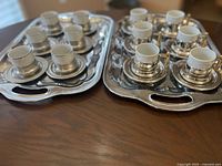 Both trays each holding 6 cups and saucers showing materials and handles