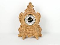 Front view of porcelain mantel clock showing dial and ornate design