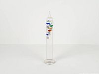 Full view of glass Galileo thermometer standing upright