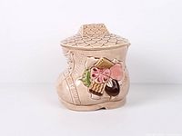 Front view of beige shoe-shaped cookie jar with flower motif