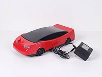 Top angle of red car-shaped VHS rewinder with power adapter