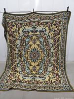 full view of woven floral tapestry throw blanket hanging to show size and pattern