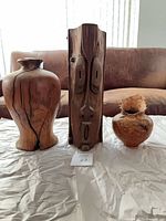 Group shot of mask and two burl vases