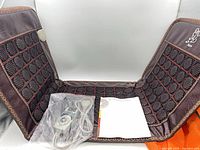 Folded-open brown jade heating pad with remote, cord and manual