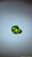 Front view of round apple-green peridot