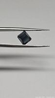 Front angled view of the octagon cut tourmaline held by tweezers