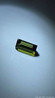 Rectangular baguette-cut green tourmaline on neutral background