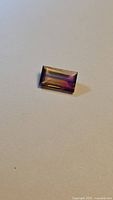 Front view of rectangular bi-colored tourmaline showing purple and yellow hues