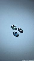 Three oval sapphires on light background showing color and cut