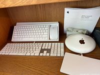 Overview of lot showing two keyboards, Magic Mouse, AirPort Extreme, external drive