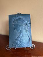 Front view of plaque on stand showing full relief image