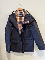 Front view of navy chore jacket on hanger