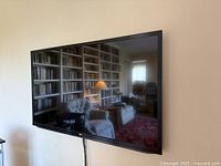 Front angled view of LG flat-panel TV mounted on wall