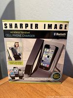 Front view of boxed Sharper Image wireless handset cell phone charger showing product image and features