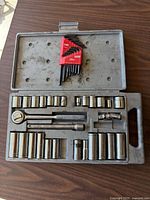 open case showing ratchet, sockets, extension, bits, and hex keys
