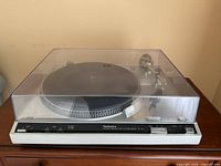 Front angled view of complete Technics SL-210 turntable with dust cover closed