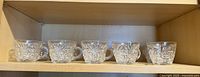 Six punch cups on upper shelf showing pattern and handles