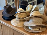 Group view of all five hats on cabinet