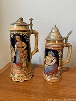 Both beer steins front view showing relative sizes and designs