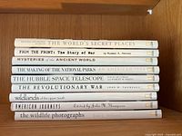side view of nine National Geographic hardcover books showing titles and condition