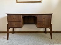 Front view of wooden mid-century desk showing drawers, legs and kneehole