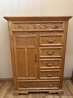 Full view of Stanley oak gentleman's chest showing drawers, door, carved trim, bracket feet