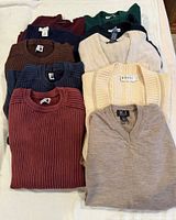 Stack of assorted folded sweaters showing variety