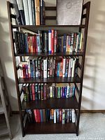 Full view of five-shelf wooden bookcase filled with books