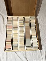 Four-row cardboard box filled with sorted trading cards