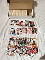 Cardboard storage box filled with hockey cards and several rows of cards laid out