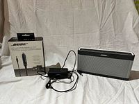 Speaker, AC adapter, boxed car charger together