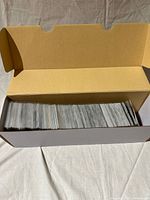 Cardboard storage box half-filled with sleeved cards