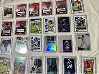 Wide view of 20 rookie cards in sleeves showing variety of Panini designs