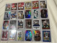 25 sleeved NFL rookie cards with various holographic and numbered parallels shown in top loaders