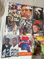 Group of nine magazines laid in three rows showing Steve Young, boxing, Tar Heels, Mike Tyson, Beckett, Slugfest, Wow covers