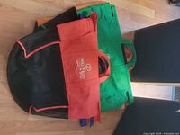 Stacked reusable Trolley Bags showing orange and green bags with mesh panels