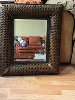 Front view of rectangular mirror showing wicker-look frame and glass