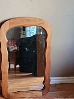 Front view of oak framed wall mirror leaning against wall