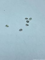 Six small loose diamonds on white background