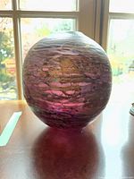 Full view of round purple and gold art glass vase