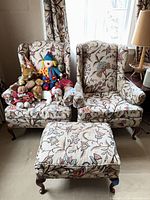 Two matching wingback armchairs, ottoman, plush toys displayed