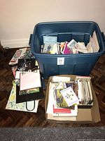 Overall lot showing envelopes, greeting cards and gift bags in bin and box