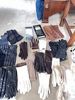 Multiple pairs leather gloves laid out showing variety of colors and lengths