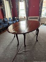 Full view of oval mahogany drop-leaf table with leaves raised