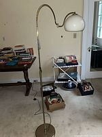 Full view of brass arc floor lamp with dome shade