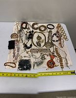 Overview of entire jewelry lot on cloth background with measuring tape