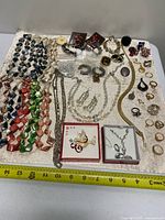 Full lot overview showing all jewelry pieces and rulers for scale