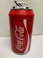Full view of Coca-Cola can mini fridge with lid and cord